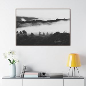 Photo of mist creeping through the trees on forest hills in a frame on a light wall